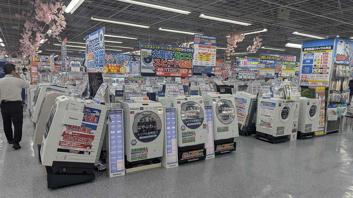 Rij wasmachines van verschillende merken naast elkaar in een winkel