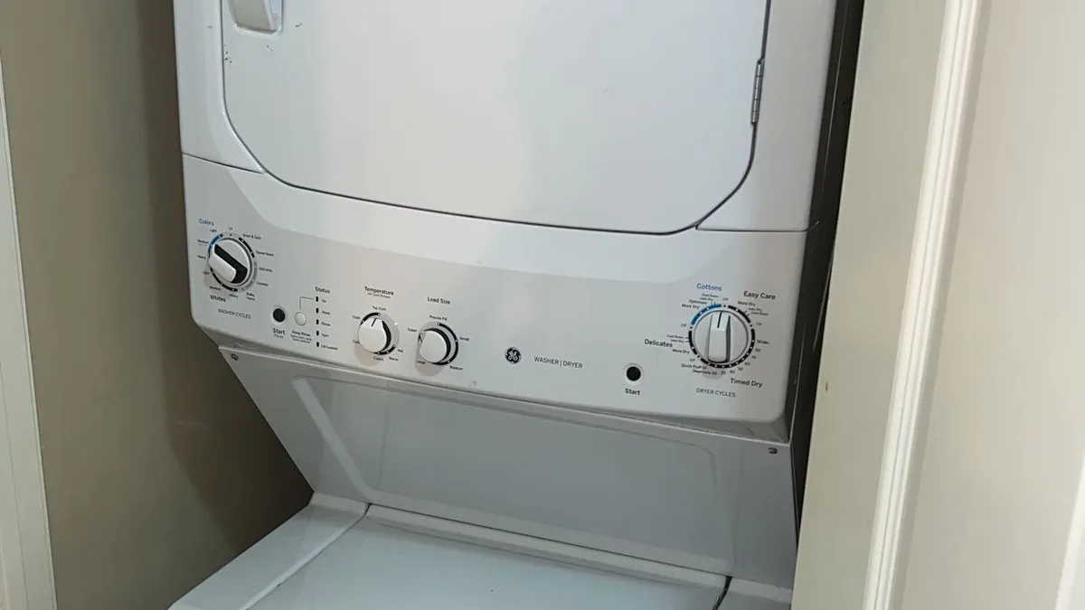 Compacte wasmachine met droogkast erboven in een smalle ruimte
